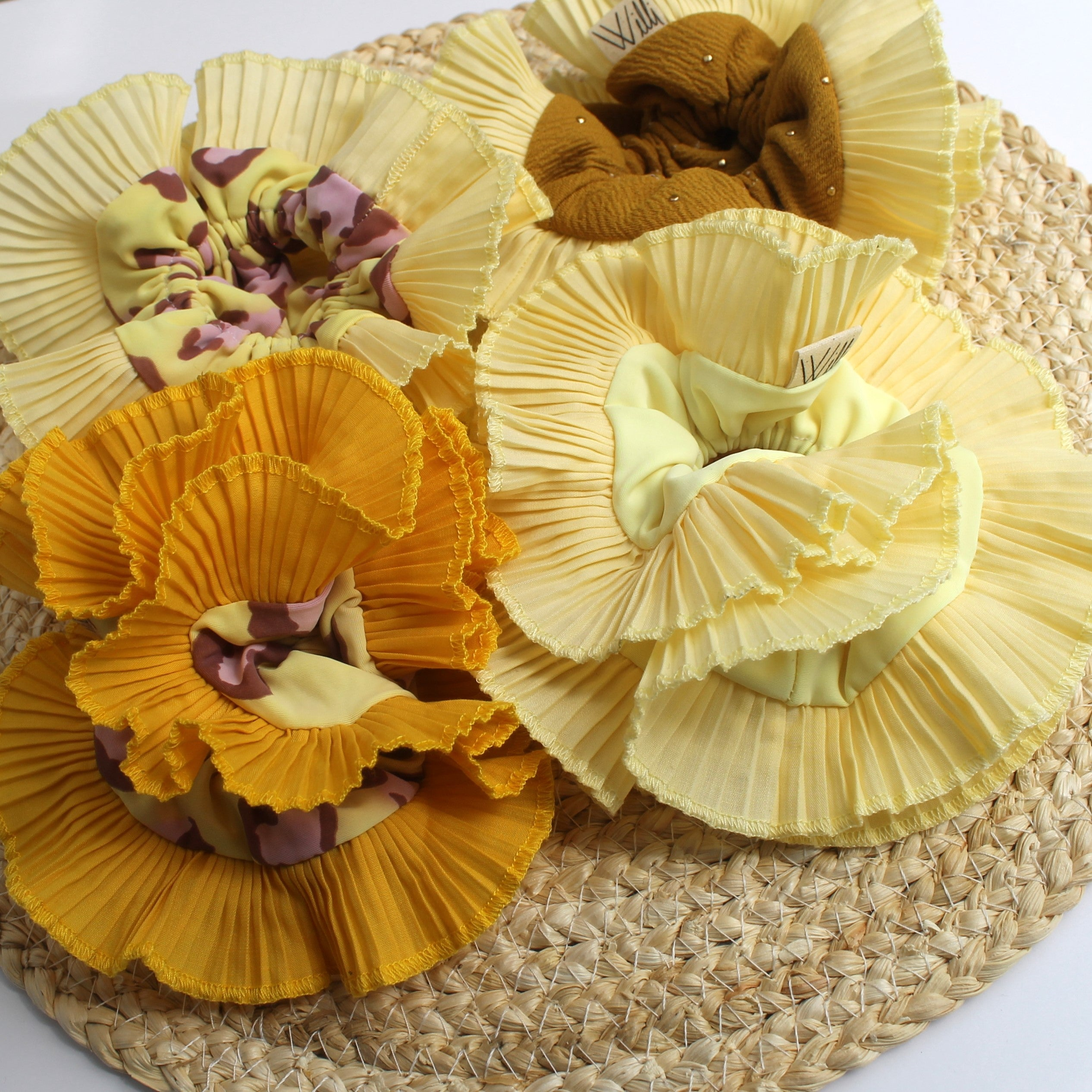four different design of yellow ruffles scrunchies over a fiver placemat