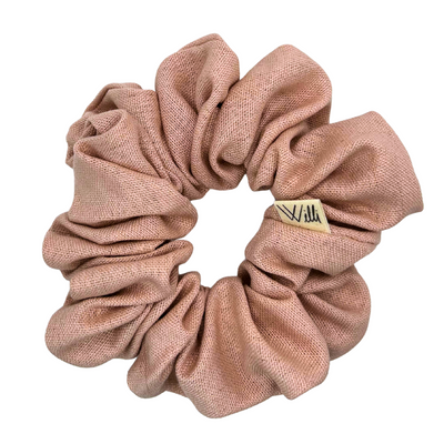Pink scrunchie with a brand tag on a white background