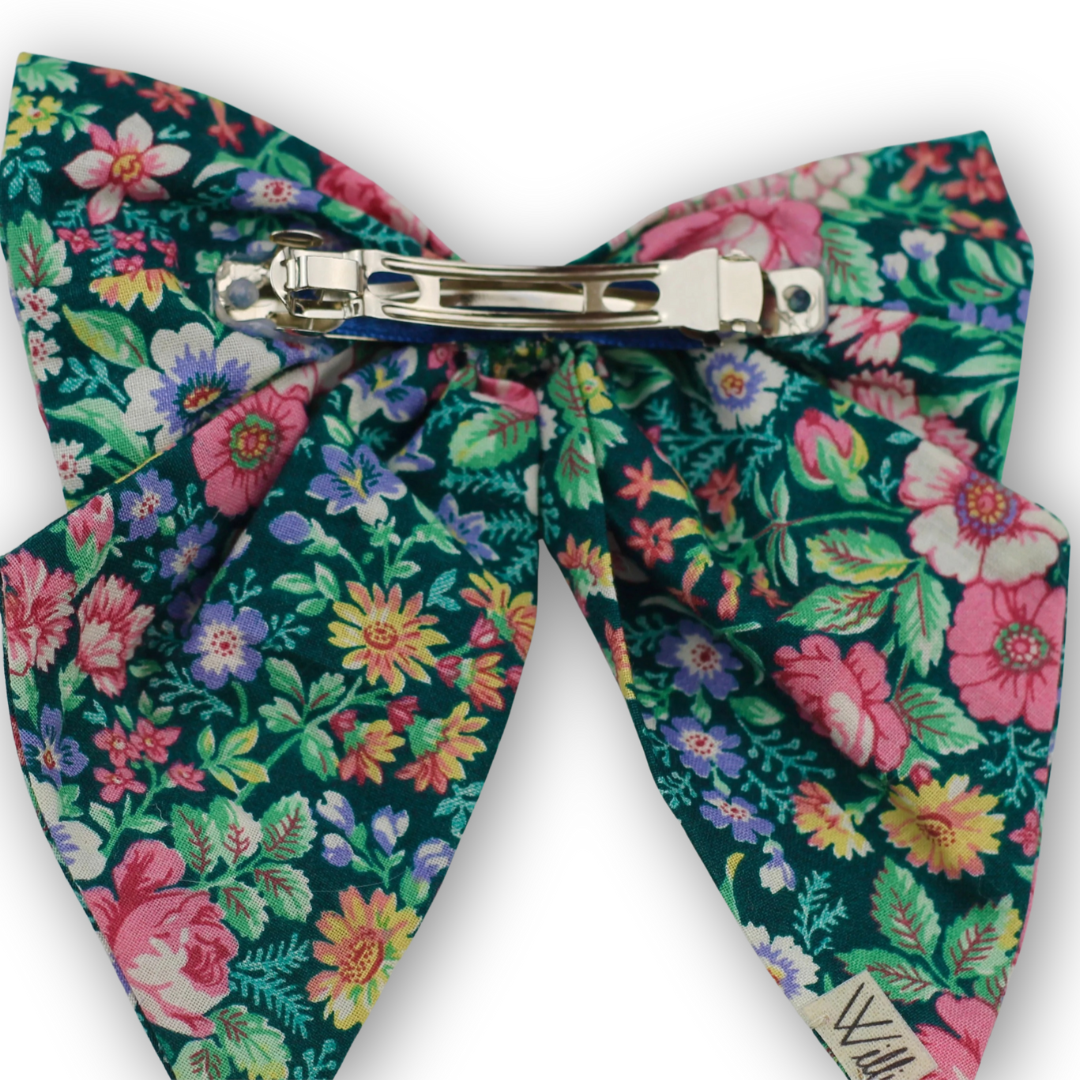 Floral patterned bow tie with a metal clip on a white background
