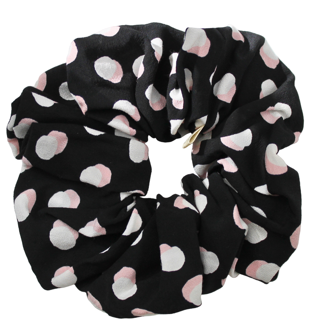 Black scrunchie with pink and white circules pattern on a white background