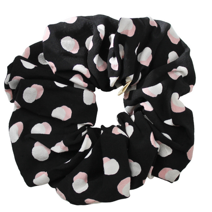 Black scrunchie with pink and white circules pattern on a white background