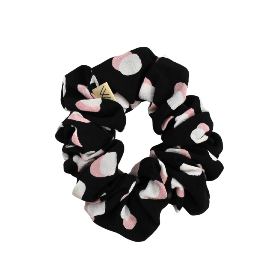 Black scrunchie with pink and white circules pattern on a white background