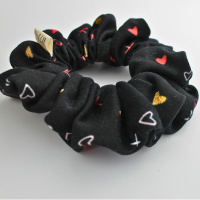 Black scrunchie with heart designs on a white background