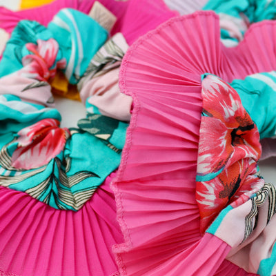 Colorful fabric pleated fans with floral patterns on a white background
