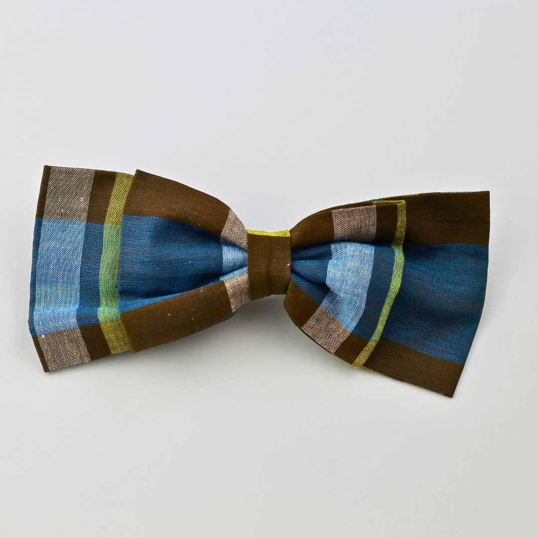 Plaid bow tie with blue, brown, and green colors on a light gray background