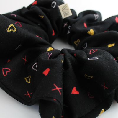Black scrunchie with colorful heart patterns on a white background