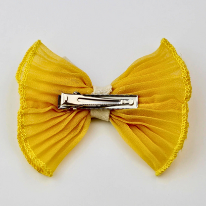 Yellow bow hair clip on a white background