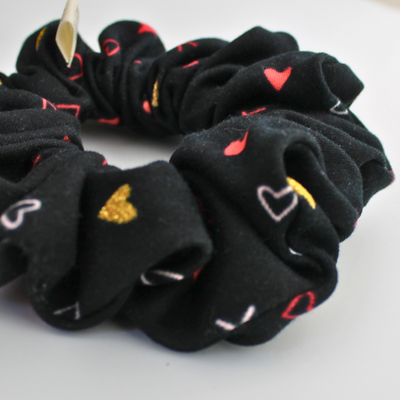 Black scrunchies with heart designs on a white background