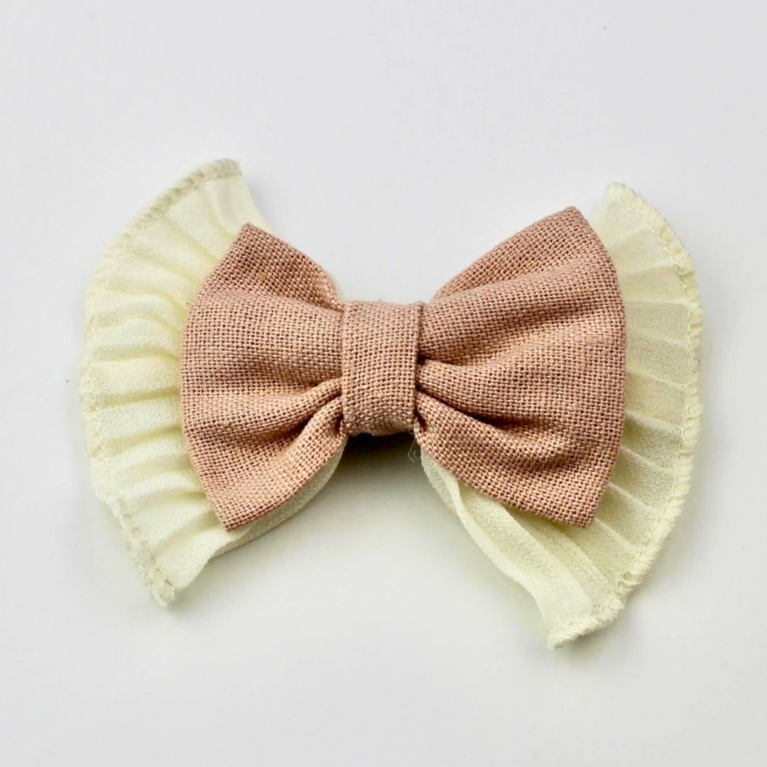 Pink bow with ruffled edges on a white background