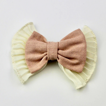 Pink bow with ruffled edges on a white background