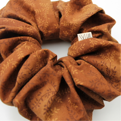 Brown scrunchie with floral pattern on a white background