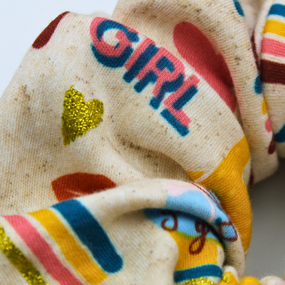 Colorful fabric with 'GIRL' text and heart shapes on a light background