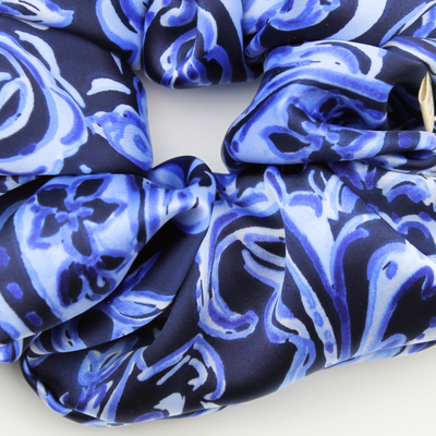 Blue and white patterned scrunchie on a white background