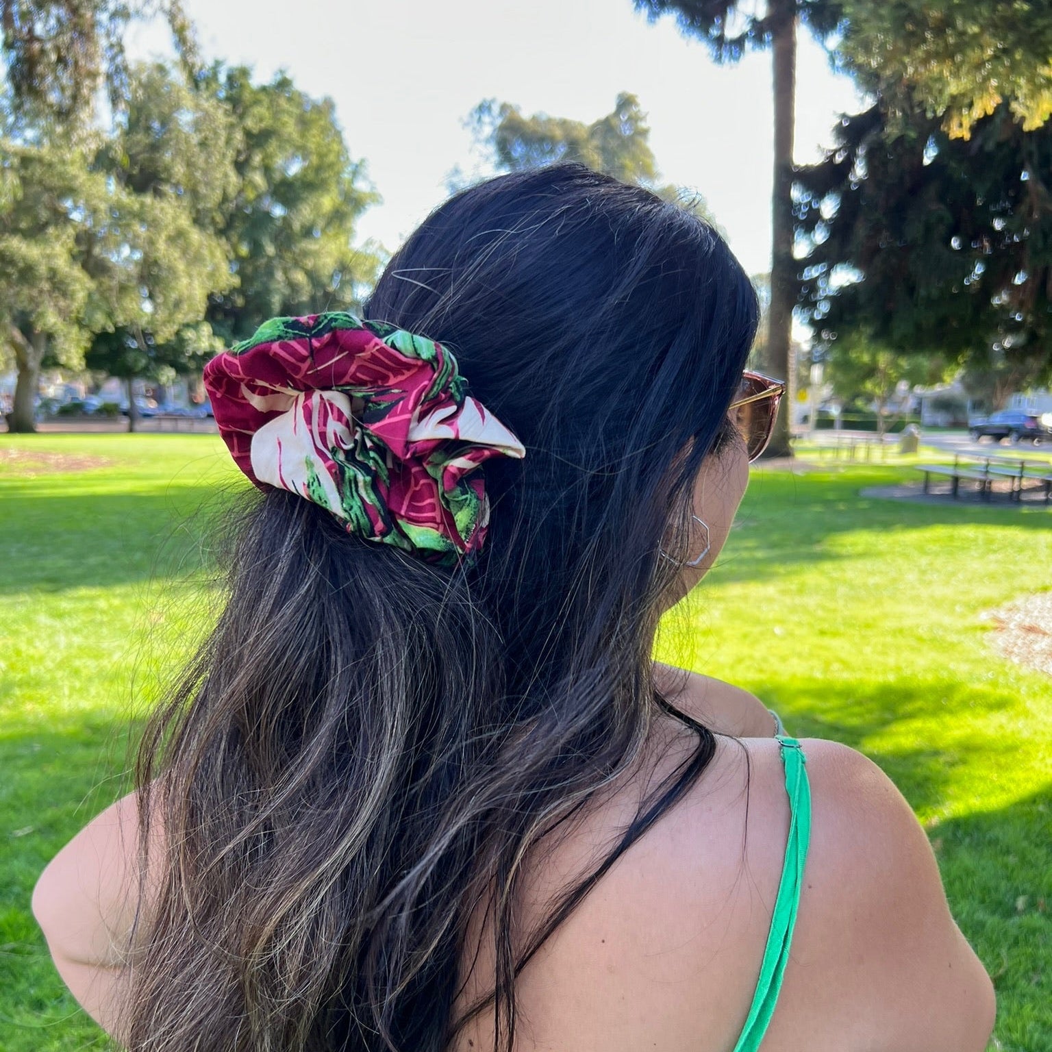 Woman with floral scrunchie in hair standing in a park