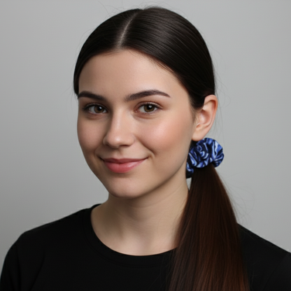 Woman with a ponytail wearing a blue scrunchie against a gray background