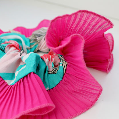 Pink hair scrunchies with colorful designs on a white background