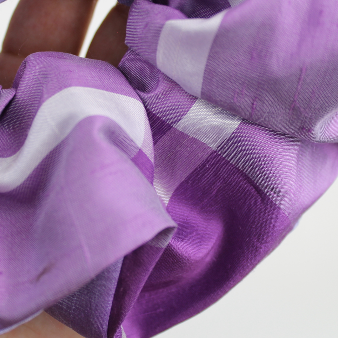 Close-up of a purple and white checkered fabric with a blurred background