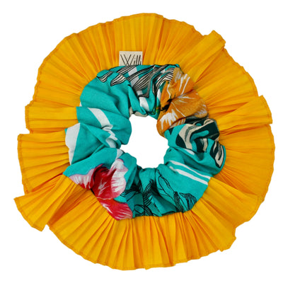 Yellow pleated fabric with colorful scrunchies on a white background