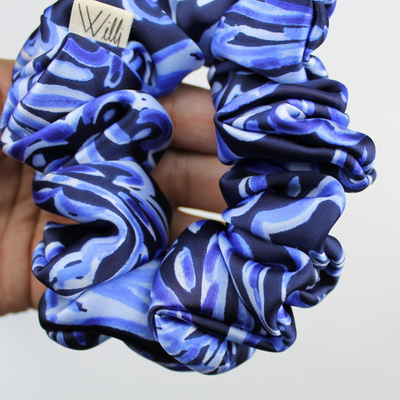Blue and black patterned scrunchies on a light gray background