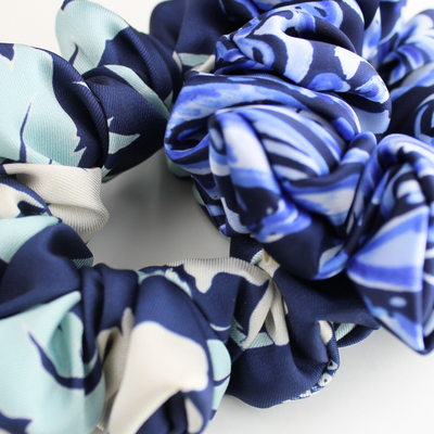 Set of blue and white patterned scrunchies on a light background