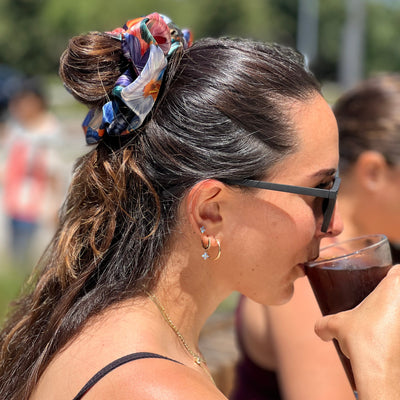 woman driking coke with a bif scrunchie in his hair